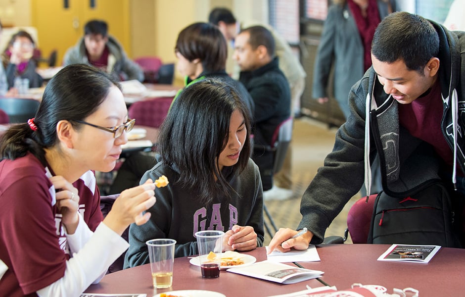 Picture of international students eating and talking at a table